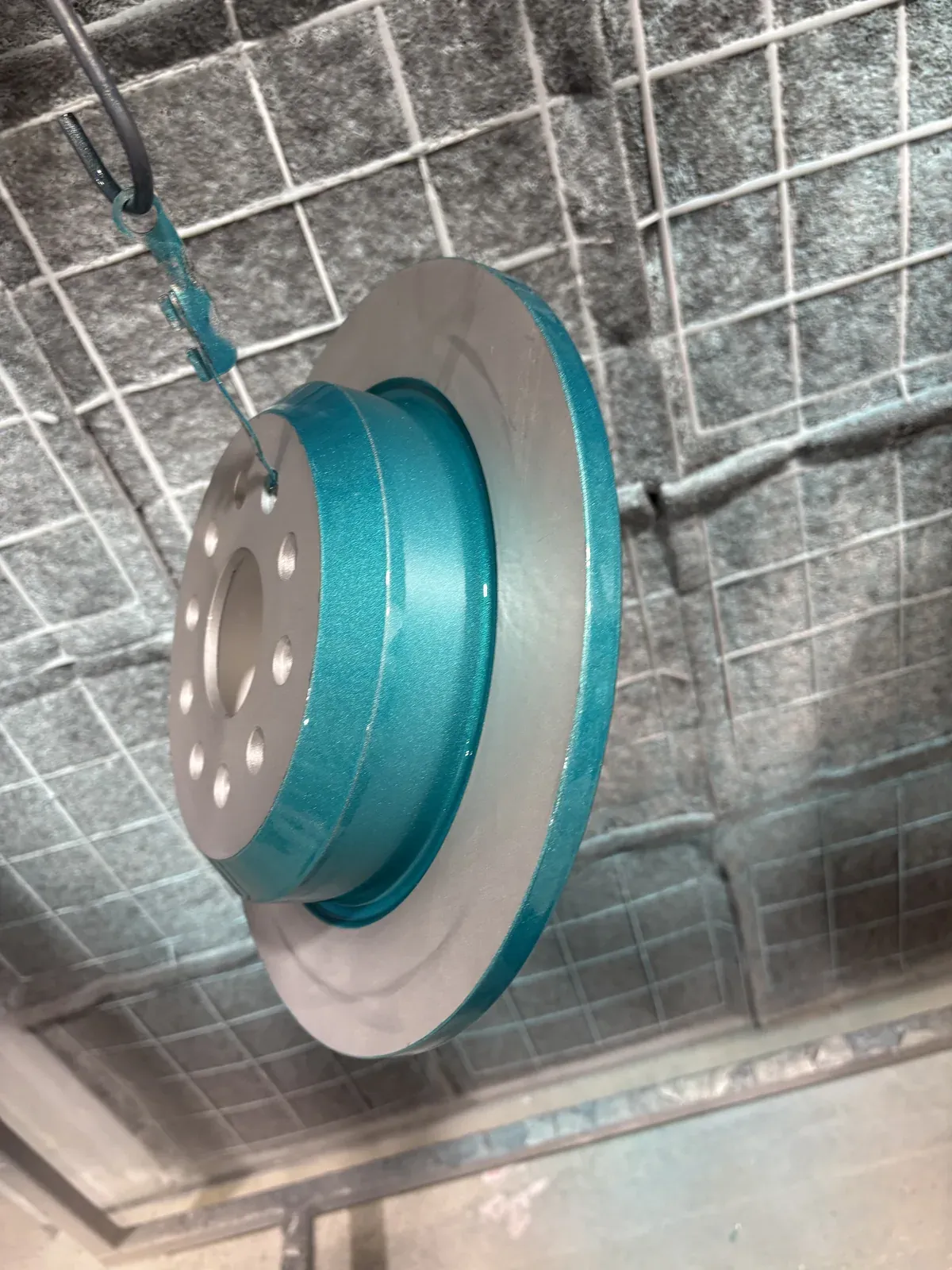Brake rotor coated teal with the friction surface masked to bare machined steel