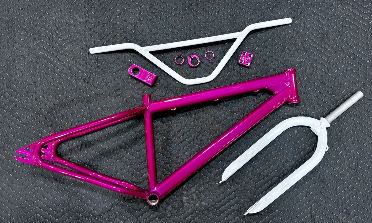 BMX bicycle frame in magenta with fork, bars and small parts finished in white